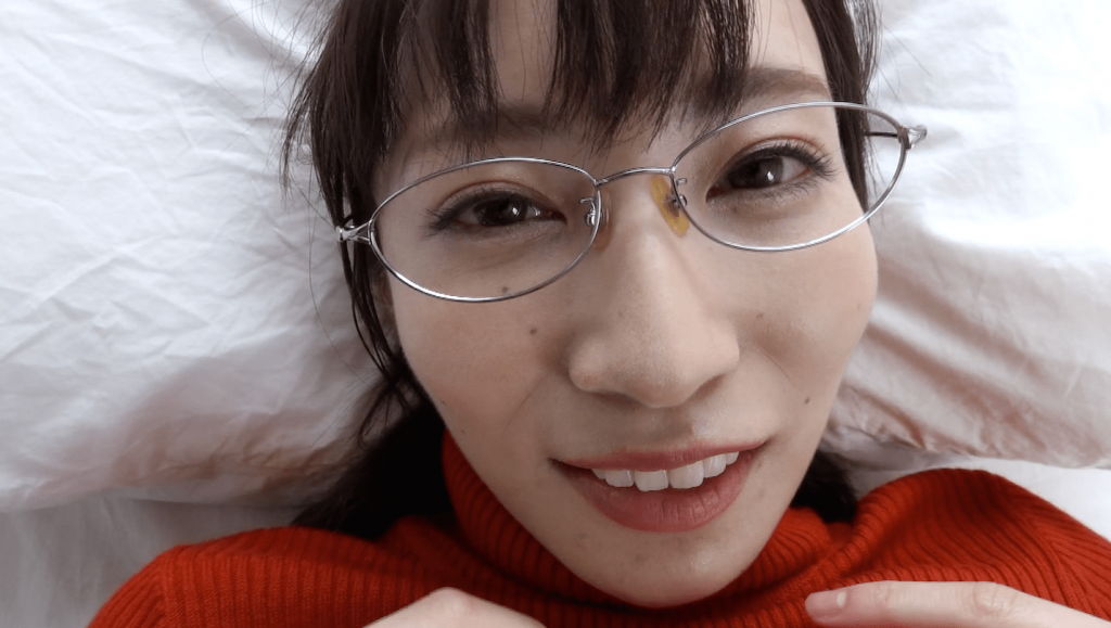 赤のセーターを着てベッドに横たわるぱつこ